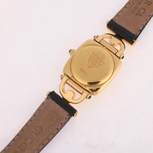 1065 - GUCCI - a lady's gold plated 6300L quartz wristwatch, blue dial with gilt leaf hands and Gucci bezel... 