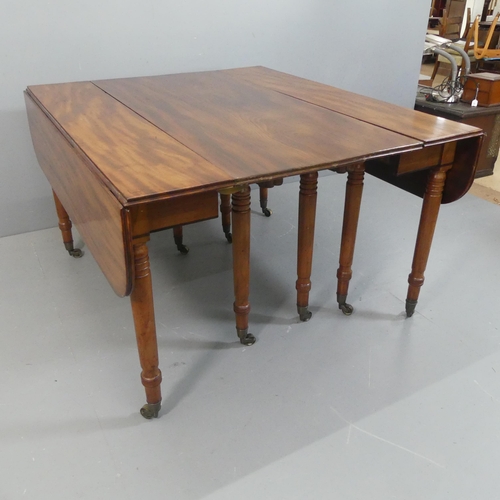 2147 - A George IV or Regency figured mahogany extending dining table, the drop flap end sections opening w... 