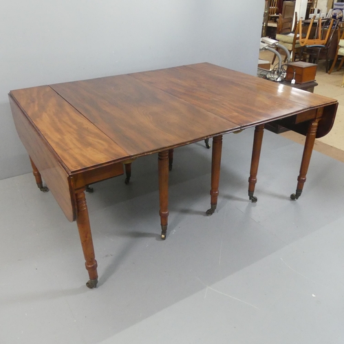 2147 - A George IV or Regency figured mahogany extending dining table, the drop flap end sections opening w... 