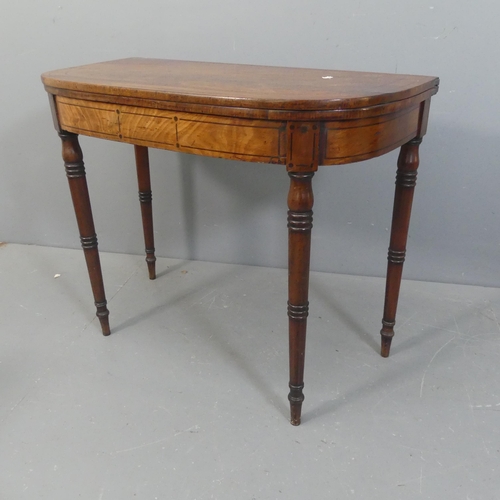 2153 - A Victorian mahogany fold-over card table, with rosewood stringing and raised on turned legs. Width ... 