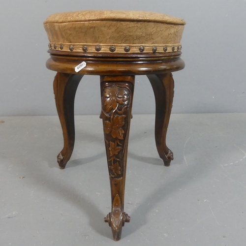 2222 - A Victorian walnut and leather upholstered stool with carved decoration. Height 46cm.