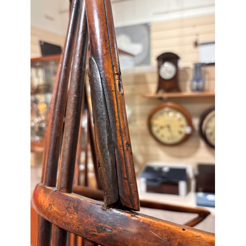 499 - An early 19th century yew wood bow arm Windsor chair, with Prince of Wales Feather design splat and ... 