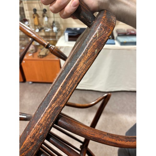 499 - An early 19th century yew wood bow arm Windsor chair, with Prince of Wales Feather design splat and ... 