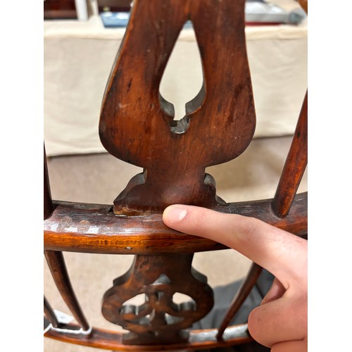 499 - An early 19th century yew wood bow arm Windsor chair, with Prince of Wales Feather design splat and ... 