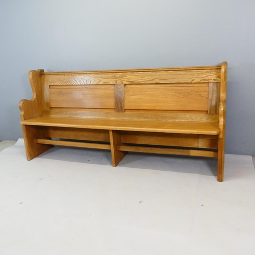 2363 - A panelled light oak church pew. Length 195cm, height 92cm, depth 49cm.