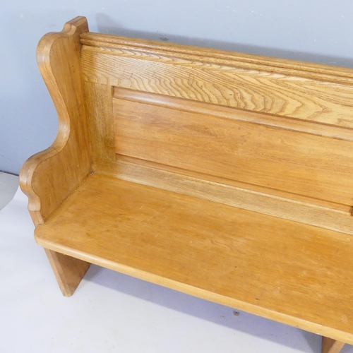 2363 - A panelled light oak church pew. Length 195cm, height 92cm, depth 49cm.