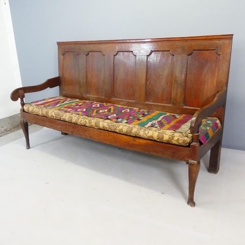 2401 - An antique panelled oak Welsh settle, with cushion over webbed seat. Overall length 189cm, height 10... 