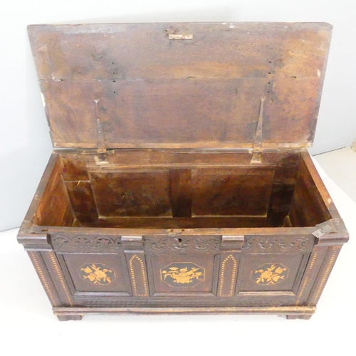 2402 - An 1th century oak blanket box, with carved and marquetry inlaid decoration and raised on stile legs... 