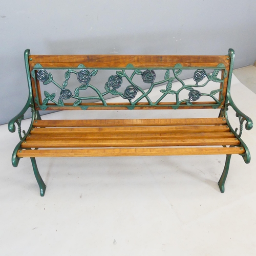 2404 - A teak slatted garden bench with cast iron ends and with floral panel to back. Length 122cm, height ... 