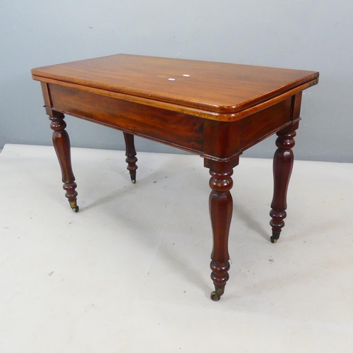 2405 - A 19th century mahogany fold-over tea table, with turned legs and brass casters. Width 107cm, height... 