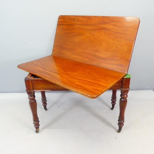 2405 - A 19th century mahogany fold-over tea table, with turned legs and brass casters. Width 107cm, height... 