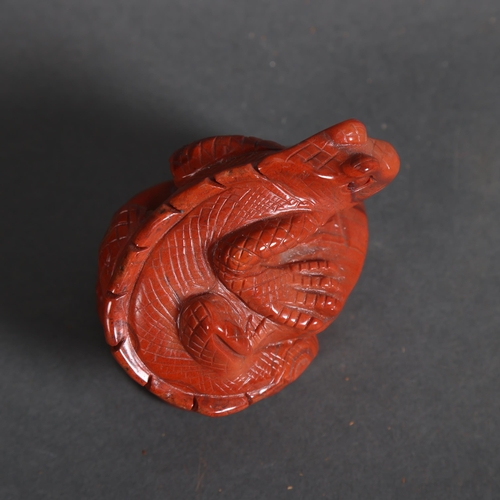 Carved Red Jasper lizard resting on rock