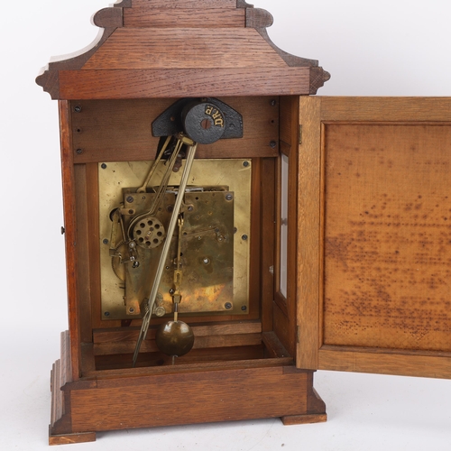307 - A carved oak-cased 8-day mantel clock, with engraved silvered dial and brass 8-day movement chiming ... 
