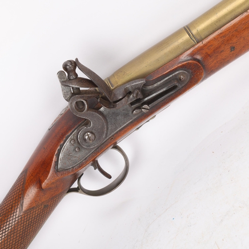 310 - A brass barrelled flintlock blunderbuss, lock signed Apnett, brass-mounted carved walnut stock, barr... 