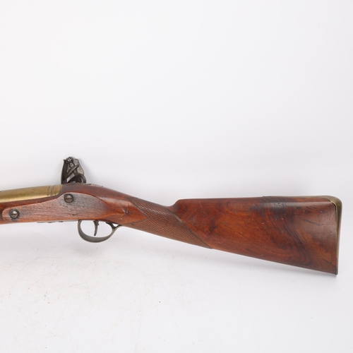 310 - A brass barrelled flintlock blunderbuss, lock signed Apnett, brass-mounted carved walnut stock, barr... 