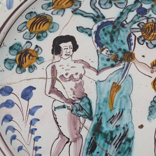311 - An 18th century English Delft charger, depicting Adam and Eve and the Tree of Knowledge with the ser... 
