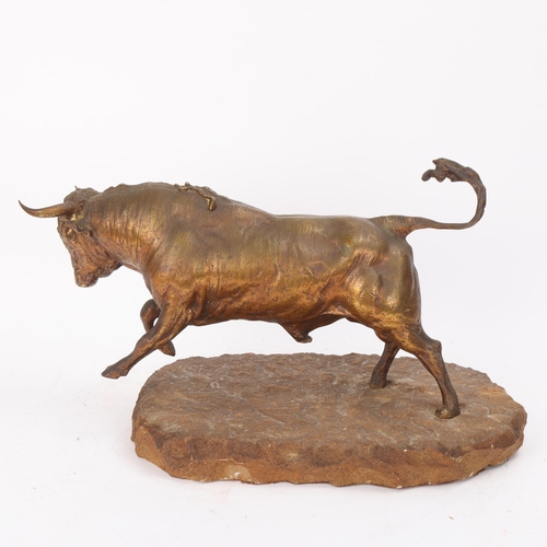 312 - A gilt-bronze charging bull, late 19th/early 20th century, unsigned on natural stone base, overall l... 