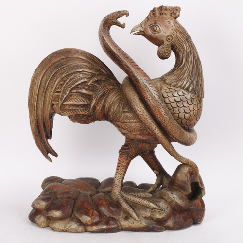 329 - A carved wood sculpture of a cobra attacking a cockerel, height 42cm