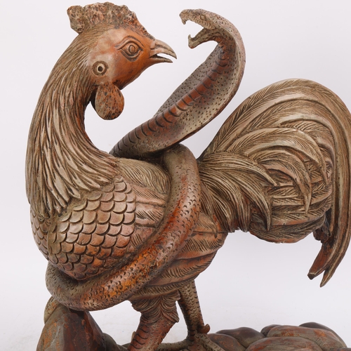 329 - A carved wood sculpture of a cobra attacking a cockerel, height 42cm