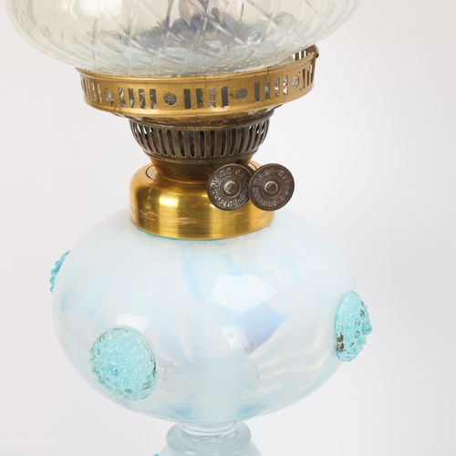 330 - **CONDITION REPORT CHANGE** A Victorian pale blue and white glass oil lamp, with applied glass bosse... 