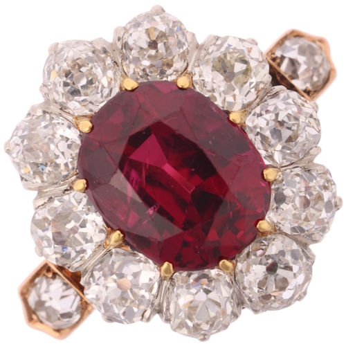 1120 - A fine 18ct gold ruby and diamond cluster ring, claw set with 2.5ct oval mixed-cut ruby surrounded b... 