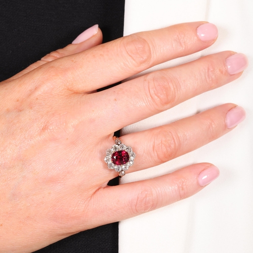 1120 - A fine 18ct gold ruby and diamond cluster ring, claw set with 2.5ct oval mixed-cut ruby surrounded b... 