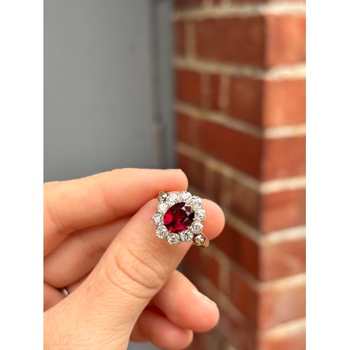 1120 - A fine 18ct gold ruby and diamond cluster ring, claw set with 2.5ct oval mixed-cut ruby surrounded b... 