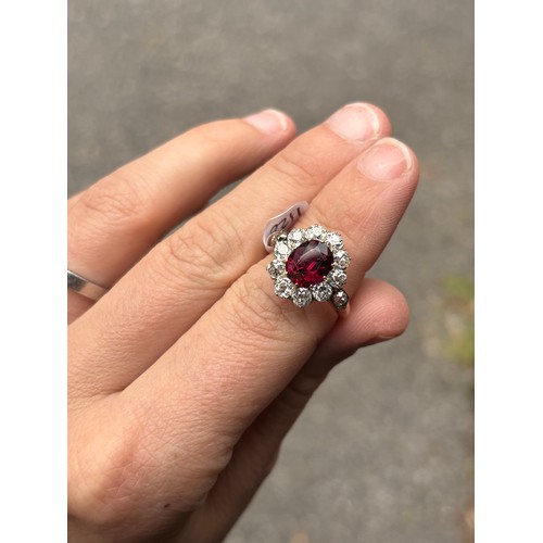 1120 - A fine 18ct gold ruby and diamond cluster ring, claw set with 2.5ct oval mixed-cut ruby surrounded b... 