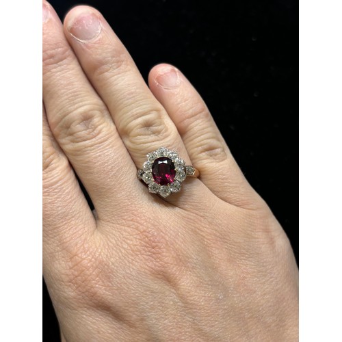 1120 - A fine 18ct gold ruby and diamond cluster ring, claw set with 2.5ct oval mixed-cut ruby surrounded b... 
