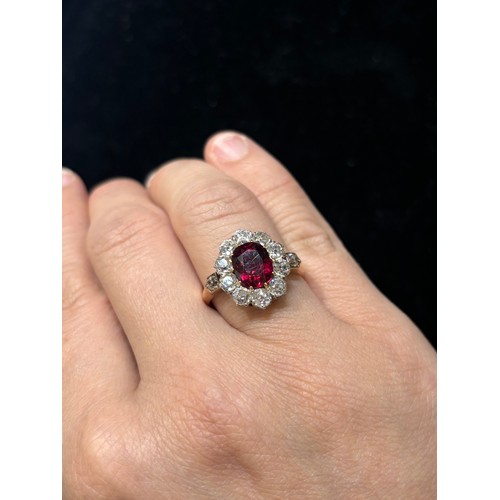 1120 - A fine 18ct gold ruby and diamond cluster ring, claw set with 2.5ct oval mixed-cut ruby surrounded b... 