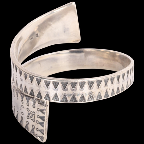 1583 - FIRMA KOPI - a Danish sterling silver Viking Revival wrap-around torque bangle, overall setting heig... 