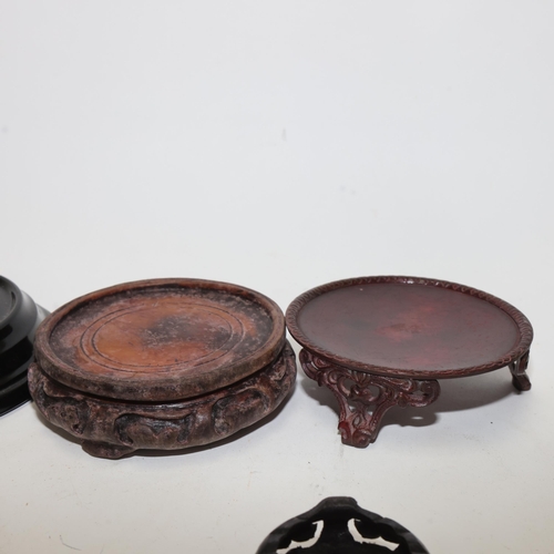 385 - A box containing 12 carved wood metal and glass Oriental stands, largest 15cm diameter