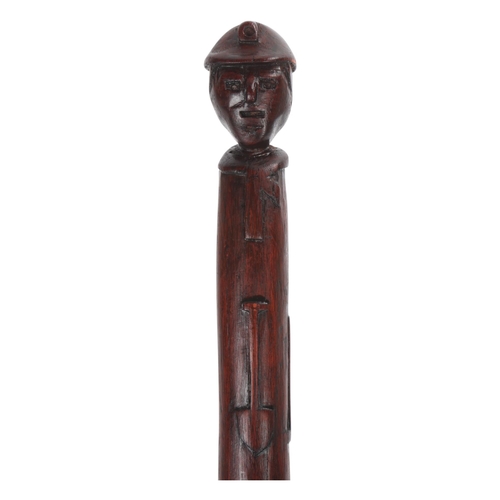 308 - A one-piece Folk Art colliers’ cane, the top carved as a helmeted miner's head with nails for eyes a... 