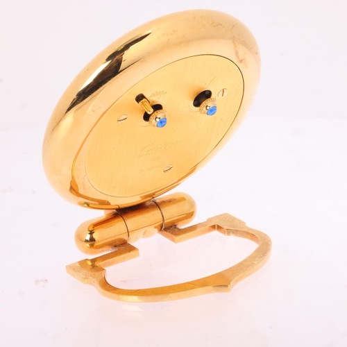1064 - CARTIER - a gilt-metal 'Colisee' quartz alarm desk clock, round white dial with black Roman numeral ... 