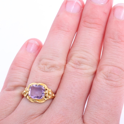 1103 - An Art Nouveau 18ct gold single stone amethyst dress ring, claw set with cushion-cut amethyst and fl... 
