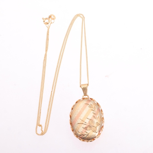 1210 - A 9ct three-colour gold locket pendant necklace, oval form, with textured and engraved decoration, o... 