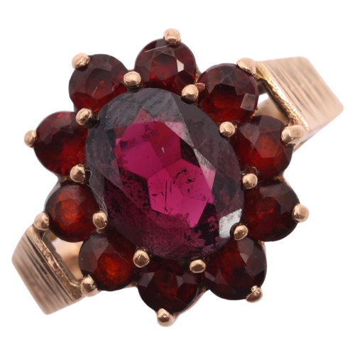 1220 - A Vintage 9ct gold garnet flowerhead cluster ring, maker G&TJ, London 1978, with textured shoulders,... 