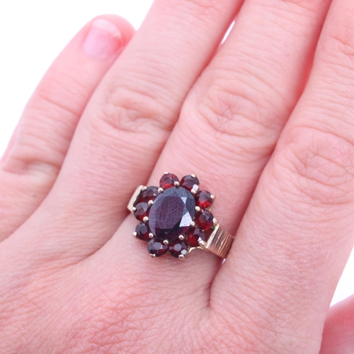 1220 - A Vintage 9ct gold garnet flowerhead cluster ring, maker G&TJ, London 1978, with textured shoulders,... 