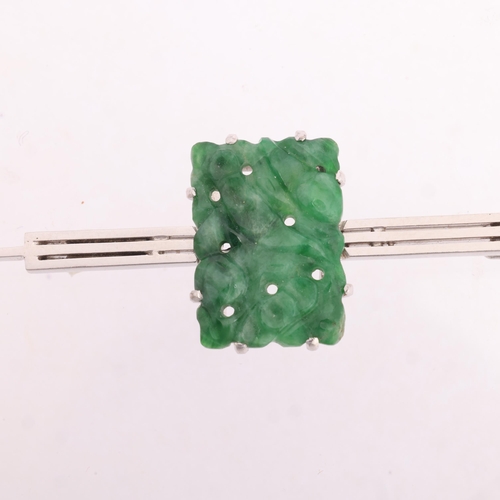 1251 - An 18ct white gold jade panel bar brooch, maker SU Ltd, the rectangular panel with pierced carved an... 