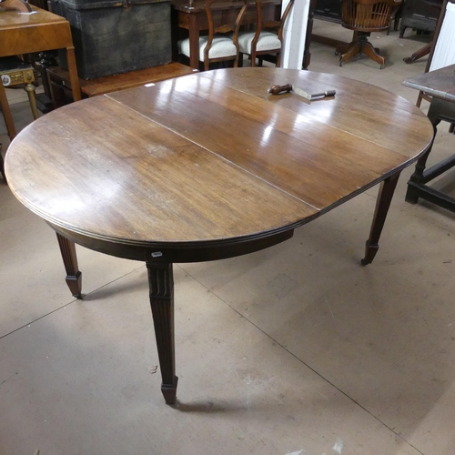 A Victorian mahogany wind-out dining table with single spare leaf and ...
