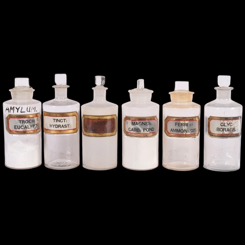 A set of 6 clear glass apothecary bottles, with stoppers and gold ...
