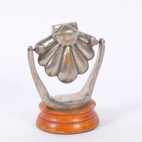 24 - An unusual revolving shell design car mascot, nickel plate brass, on wood stand, H11cm