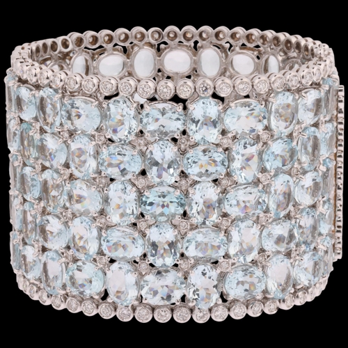 1112 - A fine 18ct white gold aquamarine and diamond hinged cuff bangle, set throughout with oval-cut aquam... 