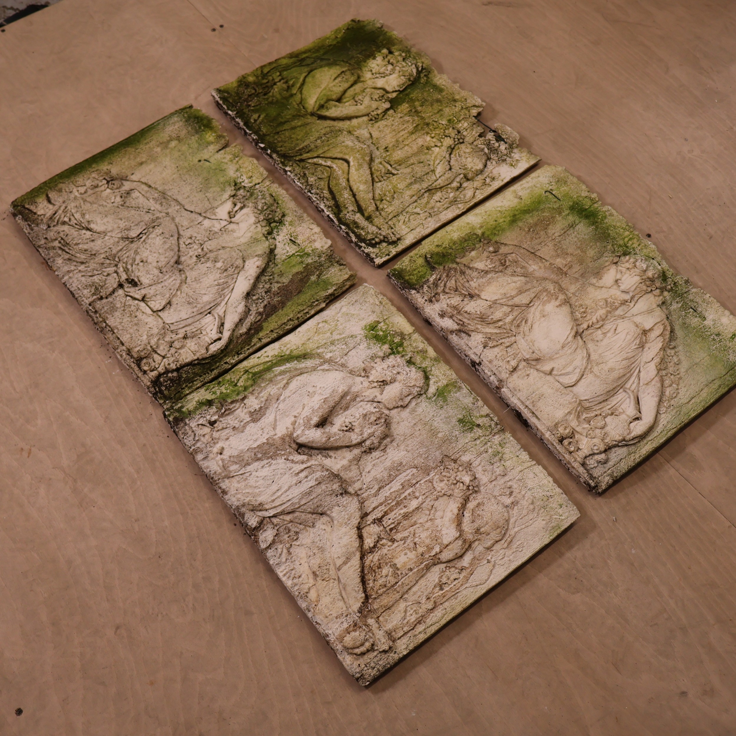 Four weathered moulded plaster wall plaques depicting classical female ...