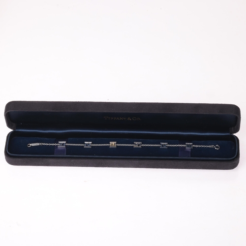 1104 - TIFFANY & CO - an 18ct white gold Atlas Collection chain bracelet, with Roman numeral stations, sign... 