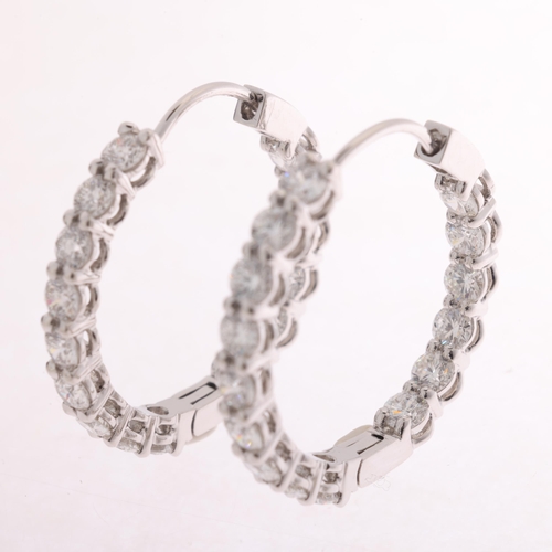 105 - TIFFANY & CO - a pair of platinum diamond hoop earrings, both set inside-out with modern round brill... 