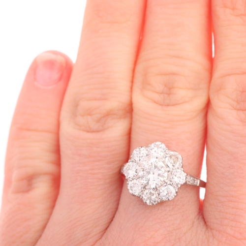117 - A platinum diamond cluster ring, centrally claw set with 0.90ct round transitional-cut diamond, surr... 