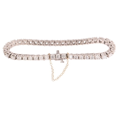125 - A 14ct white gold diamond tennis line bracelet, claw set with 43 modern round brilliant-cut diamonds... 