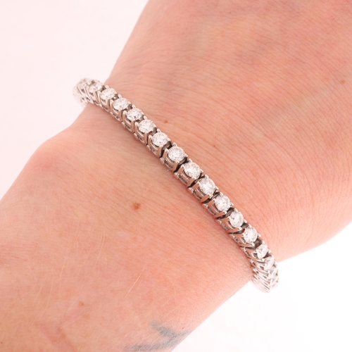 125 - A 14ct white gold diamond tennis line bracelet, claw set with 43 modern round brilliant-cut diamonds... 