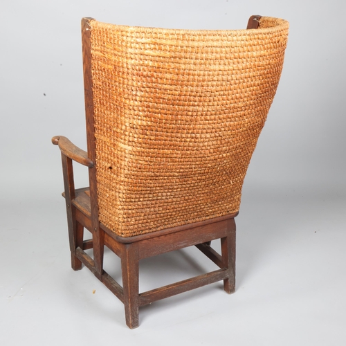 35 - An oak framed Orkney chair, having scrolled arms with wicker back and rush seat, height 99cm, height... 